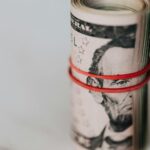 Roll of american dollars tightened with red band
